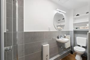a bathroom with a toilet and a sink and a mirror at Modernes Apartement am Rhein in ruhiger Lage in Cologne +19 photos