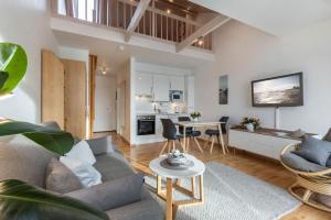 un salon avec un canapé et une table dans l'établissement Inselblume 18 - Ferienwohnung mit Meerblick & Galerie in der Strandburg, à Burgtiefe auf Fehmarn 