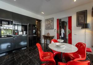 Un comedor con una mesa y sillas rojas. en Villa Yin-Noi, Private Oceanfront Villa, Kamala Beach, en Kamala Beach