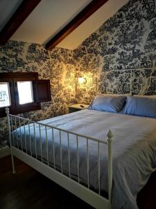a bedroom with a bed with floral wallpaper at A casa da mãe in Olivenza