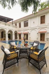 a patio with a table and chairs in front of a house at LohonoStays Villa Brisa in Anjuna