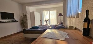 a room with a bed and a table with a bottle of wine at Magnifique Studio à louer in Evilard