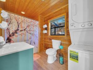 a bathroom with a white toilet and a sink at Cottage In The Pines #297 in Sevierville +44 photos