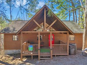 a large log cabin with a red door at Cottage In The Pines #297 in Sevierville