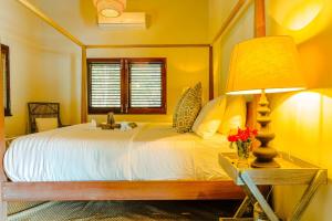 a bedroom with a large white bed with a lamp at Stunning 4 bed Villa in Bequia St Vincent in Bequia