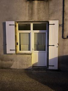 a door with two windows on a building at Chez Joseph in Mauléon