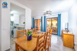 a dining room and kitchen with a wooden table and chairs at Apartamentos Los Olivos Casa Azahar in Alcossebre