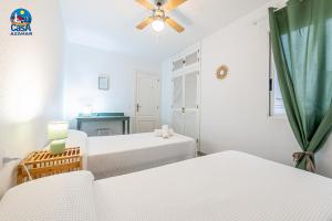 a white room with two beds and a window at Apartamentos Los Olivos Casa Azahar in Alcossebre