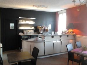 a kitchen with an island in the middle of a room at Hotel du Touring in Saint-Céré