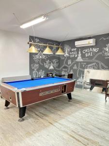 a pool table in a room with a wall with graffiti at Stay at Go Green Chiang Rai in Chiang Rai