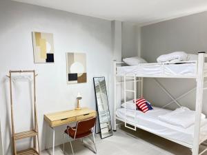a room with three bunk beds and a desk at Stay at Go Green Chiang Rai in Chiang Rai