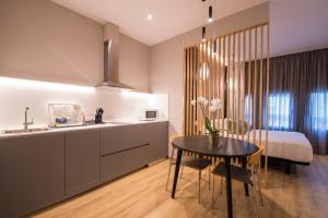 a kitchen and a bedroom with a table and a bed at Avenida Lofts in A Coruña
