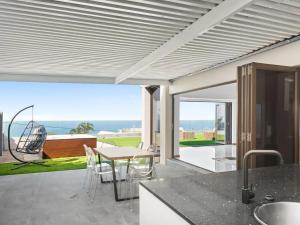 a kitchen with a table and chairs on a patio at At 40 Oceanview in Durban