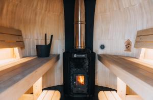 a wood stove in a room with wooden floors at Pedaspä Igloo House and Sauna in Pedaspea