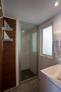 a bathroom with a glass shower and a sink at Happy Camp Mobile Homes in Valamar Camping Lanterna in Poreč