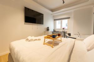 Un dormitorio con una cama con un televisor en la pared. en Platinum Jacuzzi Tsakalof 17 by Zeussuites, en Atenas