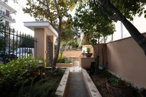 a garden with a walkway in front of a house at Niki Apartment in Athens