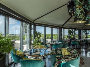 a restaurant with tables and chairs and windows at Sofitel Roma Villa Borghese in Rome