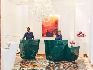 a man and woman standing at a table in a room at Sofitel Roma Villa Borghese in Rome