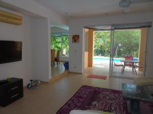 a living room with a tv and a pool at La Salamandra in Puerto Aventuras