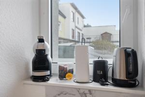 a window sill with a coffee maker and a coffee pot at Modernes Apartement am Rhein in ruhiger Lage in Cologne
