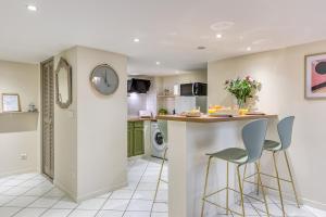 a kitchen with a counter and two stools at Chronos by Kleidos, Grand duplex, 4 personnes, 3 minutes Gros Horloge & Opéra de Rouen in Rouen