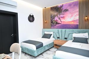 a hotel room with two beds and a couch at Vila La Familia in Ksamil