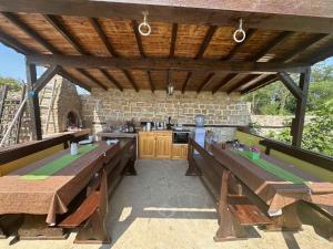 patio al aire libre con mesas de madera y cocina en Вила Хейла, en Voditsa