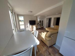 Una sala de estar con una mesa blanca y un sofá. en Вила Хейла, en Voditsa