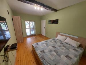 Un dormitorio con una cama en una habitación con suelo de madera. en Вила Хейла, en Voditsa 15 fotos más