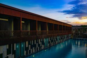 a building with a swimming pool with a sunset in the background at Haywizz Havelock Island Resort in Havelock Island +12 photos