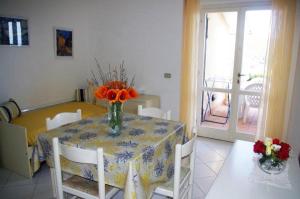 Una mesa de comedor con un jarrón de flores encima. en Residence Capo Morcone, en Capoliveri