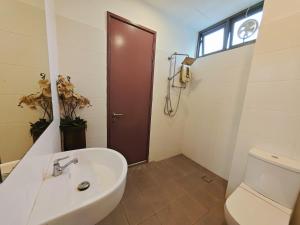 a bathroom with a toilet and a sink and a door at 2 Spacious Lupsxury conor villa garden Parking group family gathering wedding in Gelugor +22 photos