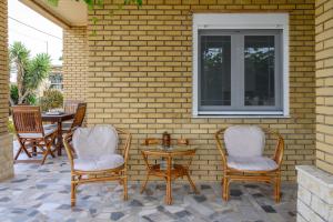 a patio with chairs and a table and a window at Summer Tan in Megás Limniónas