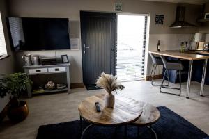 a living room with a table and a tv at Noel's Place in Doolin +7 photos
