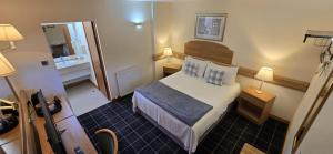 フォッシャバーズにあるThe Red Lion Tavernのベッドと鏡のある小さな部屋