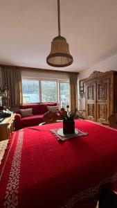 a living room with a red bed with a red blanket at La Sibilla in Riscone