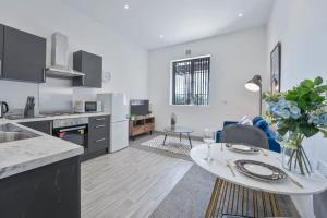 Una cocina y una sala de estar con una mesa y un sofá. en Modern & Cosy 1 Bedroom Budget Apartment in Dudley, en Brierley Hill