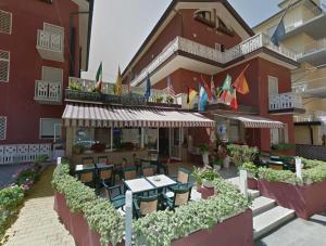 a restaurant with tables and chairs in front of a building at Hotel Malibran in Lido di Jesolo