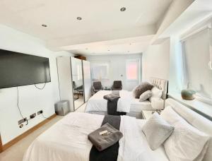 a hotel room with two beds and a flat screen tv at Razak House in Brighton & Hove