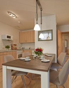 eine Küche mit einem Esstisch und Stühlen in der Unterkunft Ferienwohnung in Otterndorf in Otterndorf