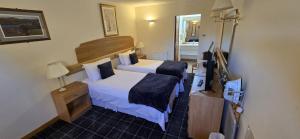 a hotel room with two beds and a television at The Red Lion Tavern in Fochabers +26 photos