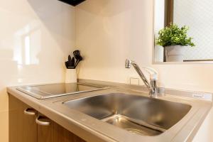 Y's INN 渋谷本町 019T في طوكيو: حوض حديد قابل للصدأ في مطبخ مع نافذة +55 صورة