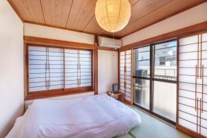 Y's INN 渋谷本町 019T في طوكيو: غرفة نوم بسرير ابيض ونوافذ