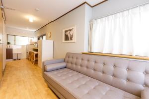 Y's INN 渋谷本町 019T في طوكيو: غرفة معيشة مع أريكة ونافذة