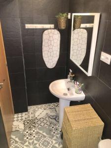 un bagno con lavandino e specchio di Apartamento centro a Murcia Altre 11 foto