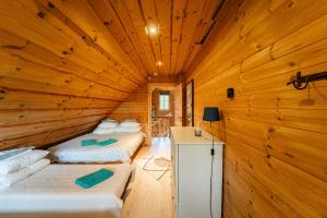 a room with two beds in a wooden cabin at Saarelux Riverise Villa in Mõraste