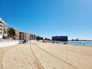 a view of a sandy beach with buildings and the ocean at Bungalow Malibu Complex Doa Pepa- Rojales in Ciudad Quesada