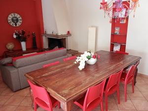 a living room with a wooden table and red chairs at B&B La Giostra di Foligno in Foligno