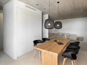 ein Esszimmer mit einem Holztisch und schwarzen Stühlen in der Unterkunft Design Villa Nea Skioni by Halkidiki Villas in Nea Skioni + 46 Fotos